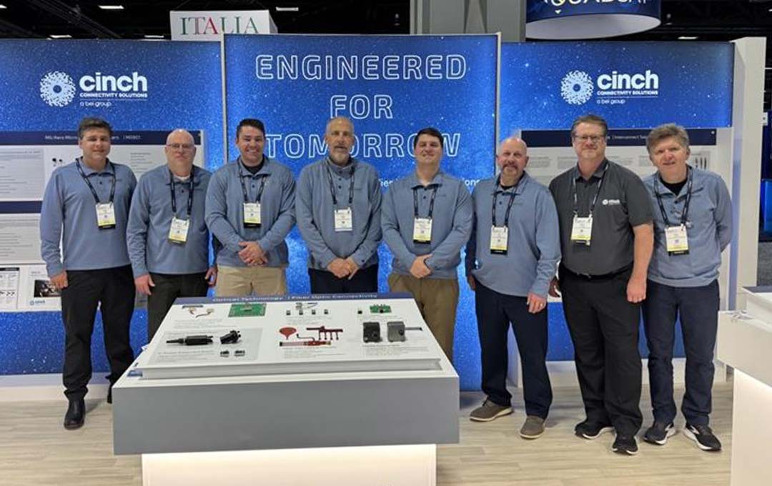 Cinch team members standing at an event booth in front of a sign that reads Engineered for Tomorrow
